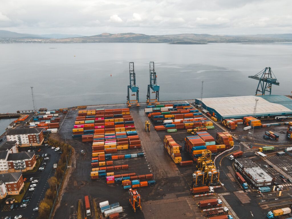 Aerial shot of a busy container port in Scotland with cranes and colorful cargo containers.