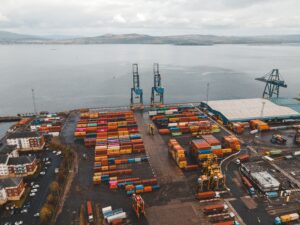 Aerial shot of a busy container port in Scotland with cranes and colorful cargo containers.